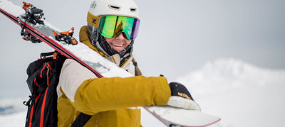 skier smiling and holding skis